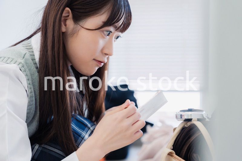 学校でメイクをする女子高生