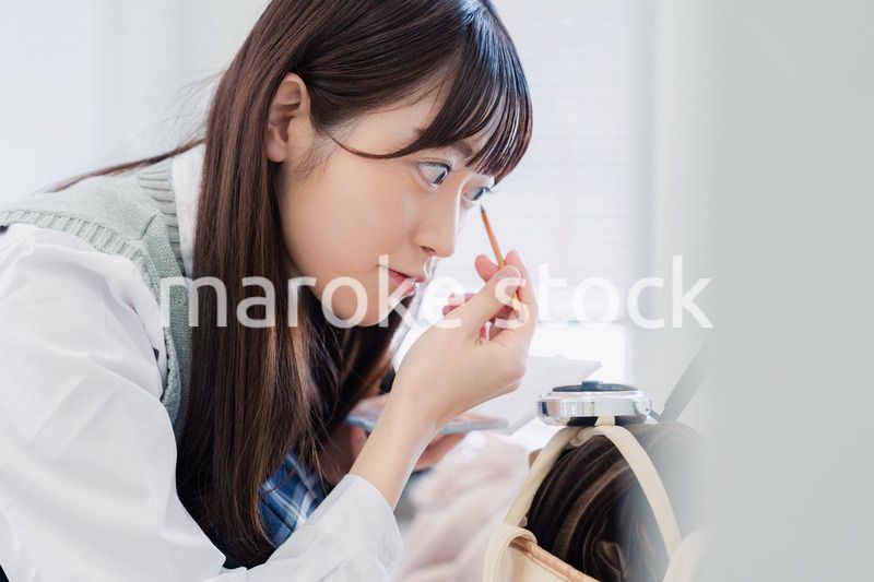 学校でメイクをする女子高生