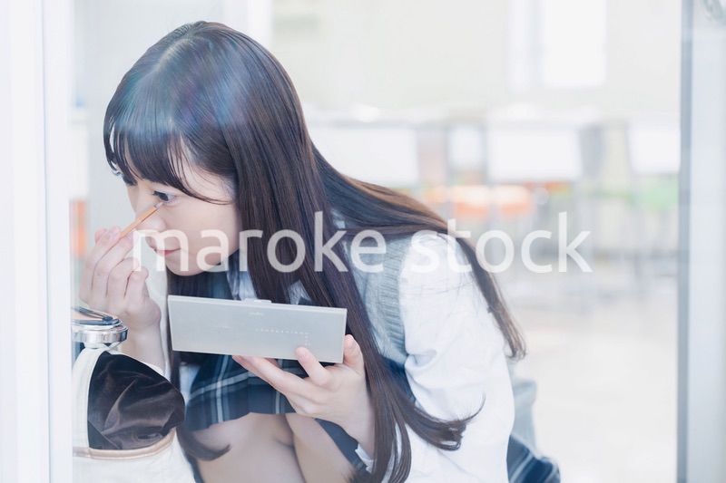 学校でメイクをする女子高生