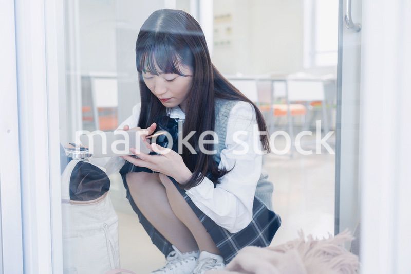 学校でメイクをする女子高生