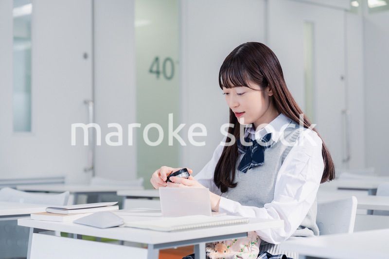 学校でメイクをする女子高生