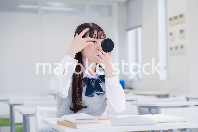 学校でメイクをする女子高生
