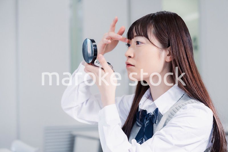 学校でメイクをする女子高生