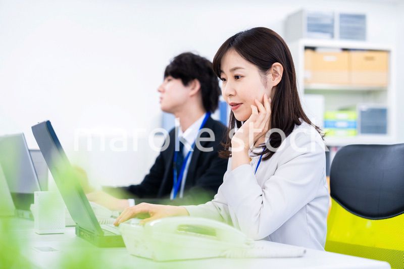 笑顔でデスクワークをする女性