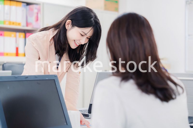 オフィスで相談をする2人の女性会社員