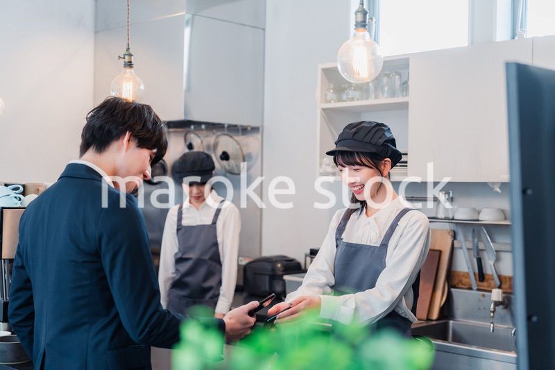 スマホでタッチ決済をする男性