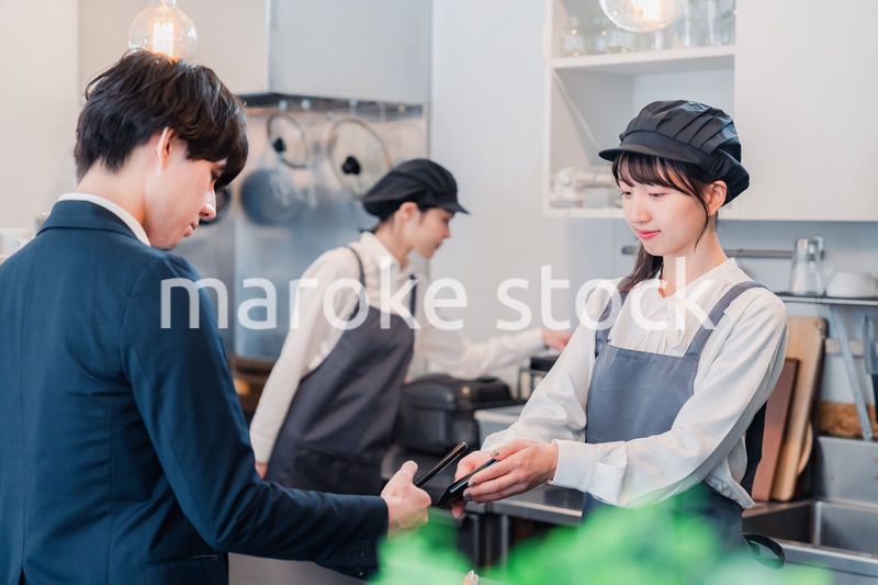 スマホでタッチ決済をする男性