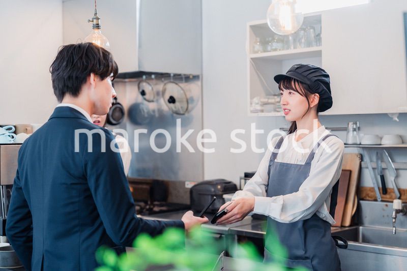 スマホでタッチ決済をする男性