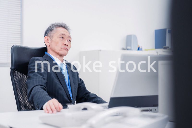 会社で自分の意見を語る管理職の男性