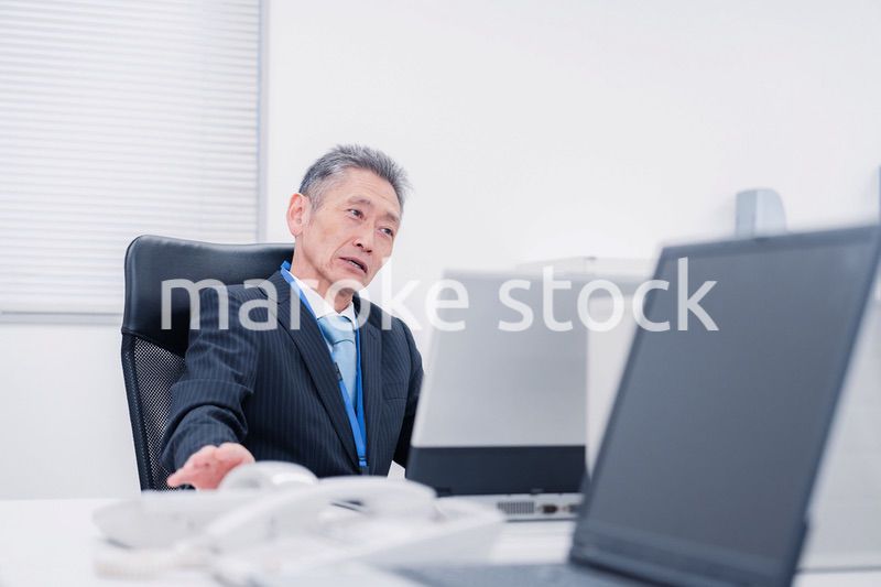 会社で自分の意見を語る管理職の男性