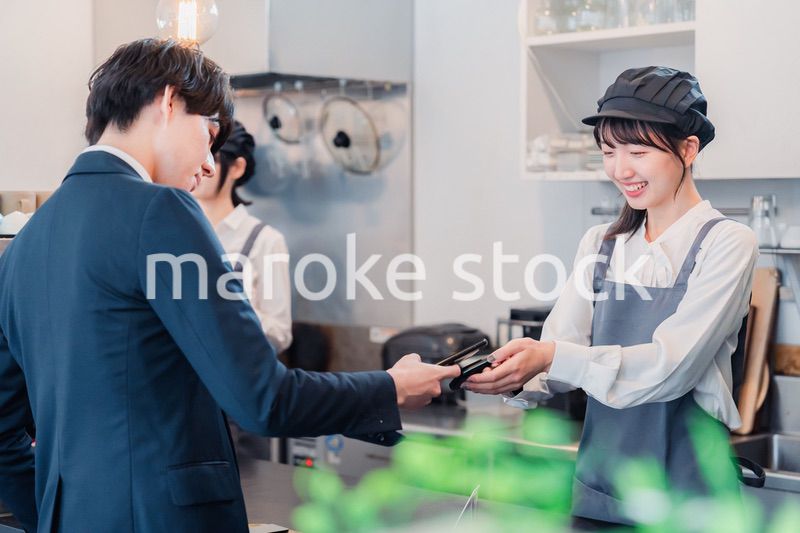 スマホでタッチ決済をする男性