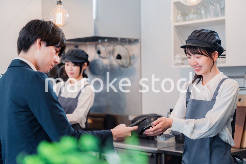 スマホでタッチ決済をする男性