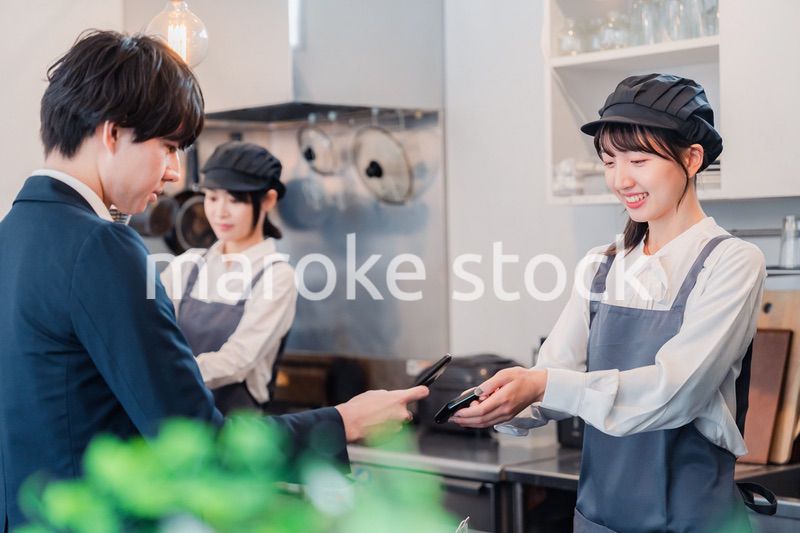 スマホでタッチ決済をする男性