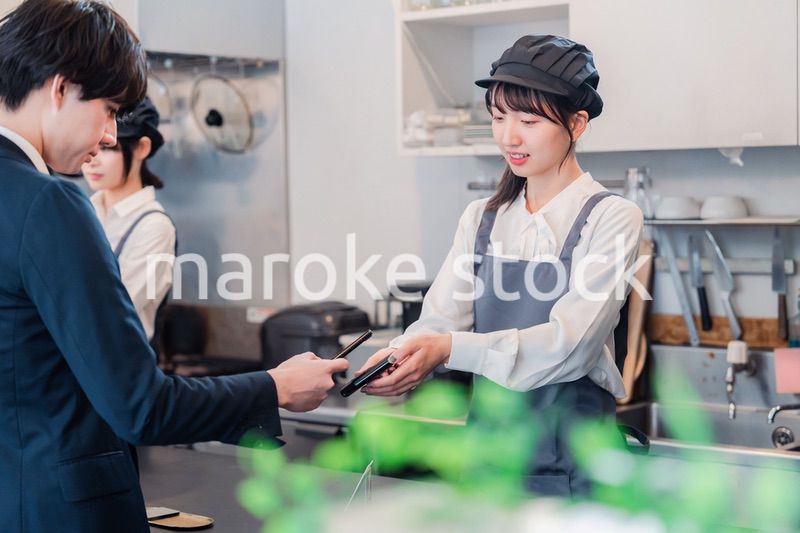 スマホでタッチ決済をする男性