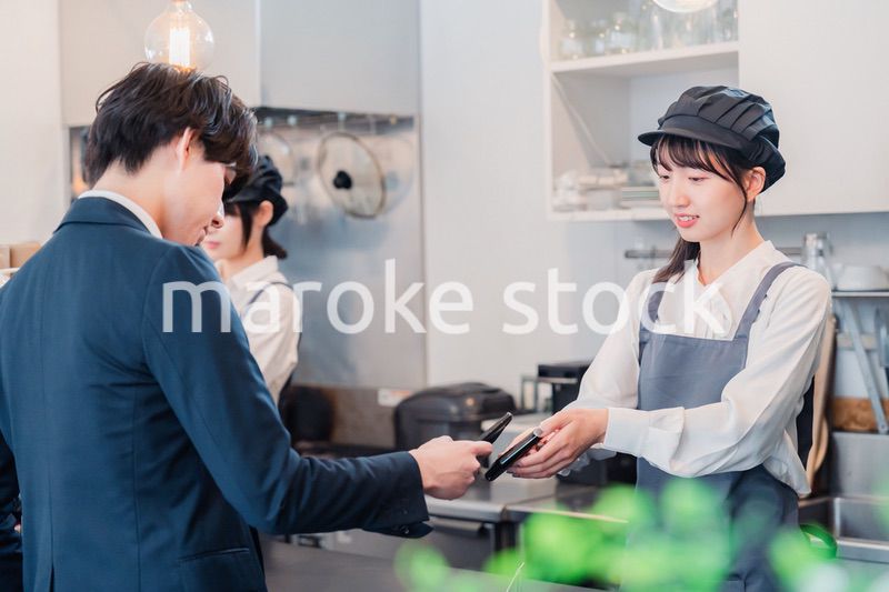 スマホでタッチ決済をする男性