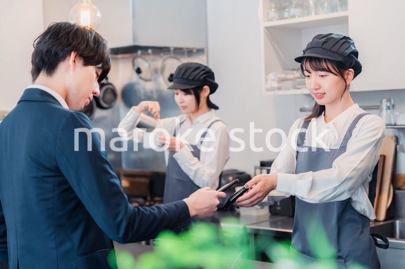 スマホでタッチ決済をする男性