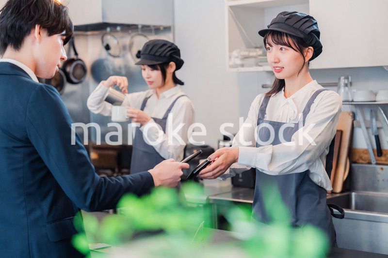 スマホでタッチ決済をする男性