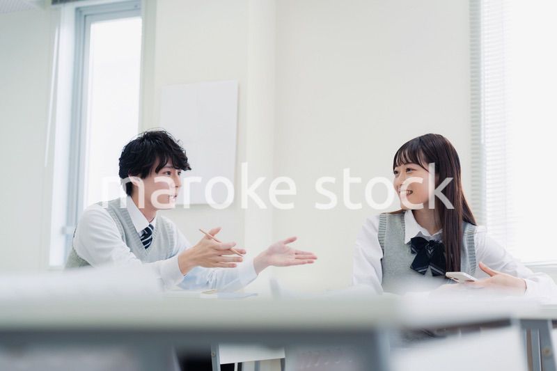 同級生と教室で仲良く話す高校生