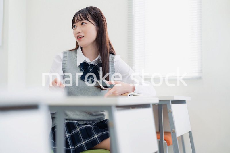 同級生と教室で仲良く話す高校生