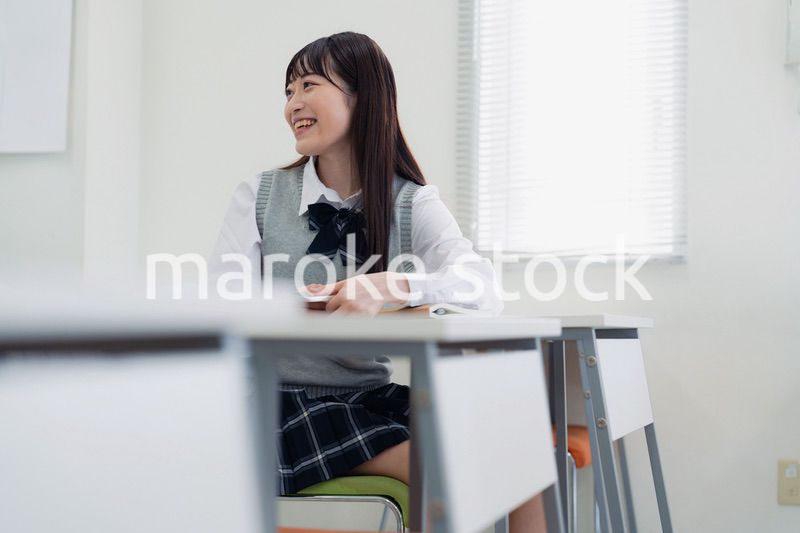 同級生と教室で仲良く話す高校生