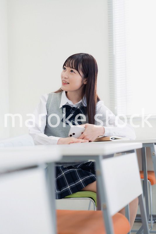 同級生と教室で仲良く話す高校生