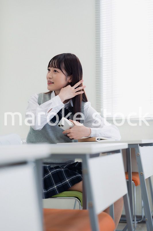 同級生と教室で仲良く話す高校生