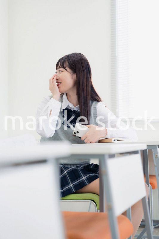 同級生と教室で仲良く話す高校生