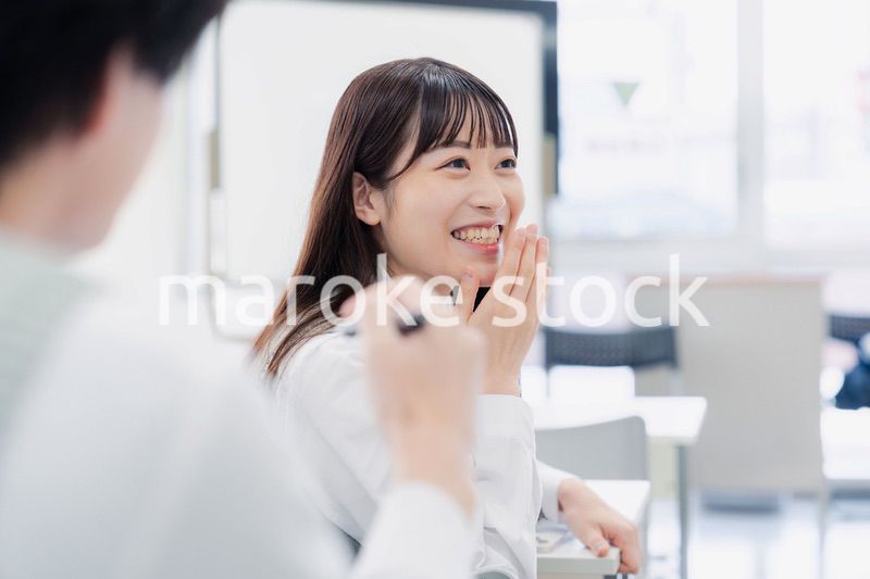 同級生と教室で仲良く話す高校生