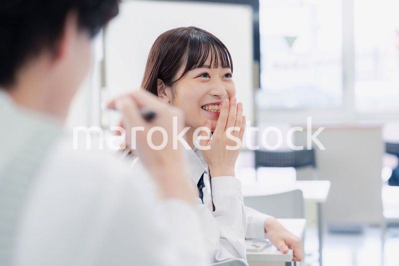 同級生と教室で仲良く話す高校生