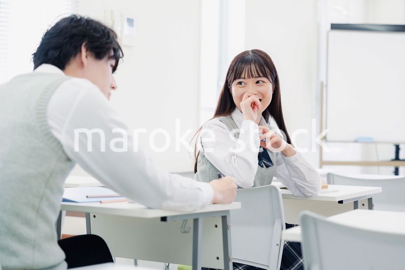 同級生と教室で仲良く話す高校生