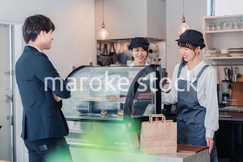 ケーキ屋で楽しく買い物をするビジネスマン