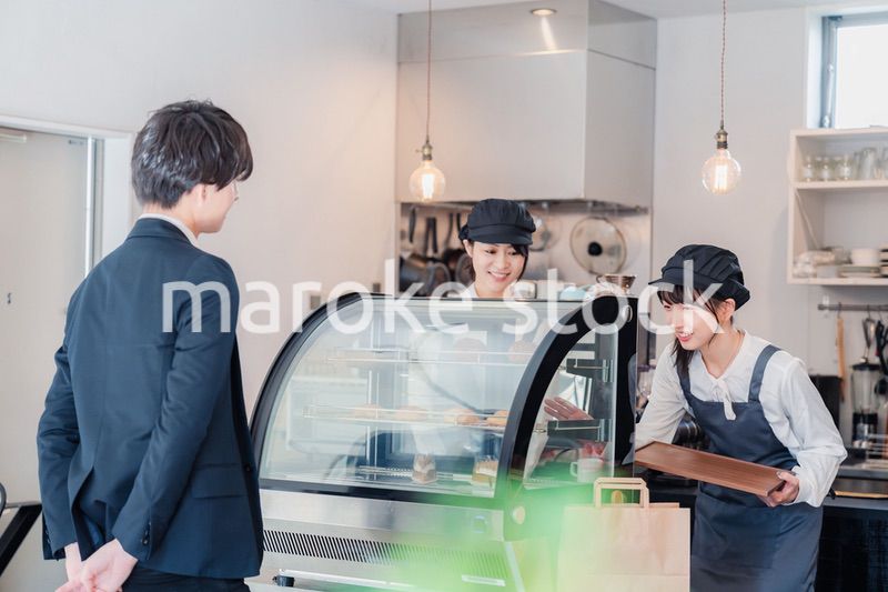 ケーキ屋で楽しく買い物をするビジネスマン