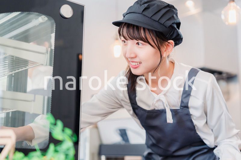 ショーケースに商品を並べる若い店員