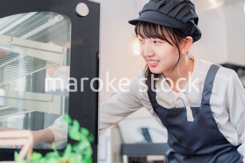 ショーケースに商品を並べる若い店員