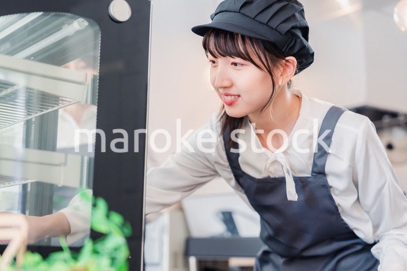 ショーケースに商品を並べる若い店員