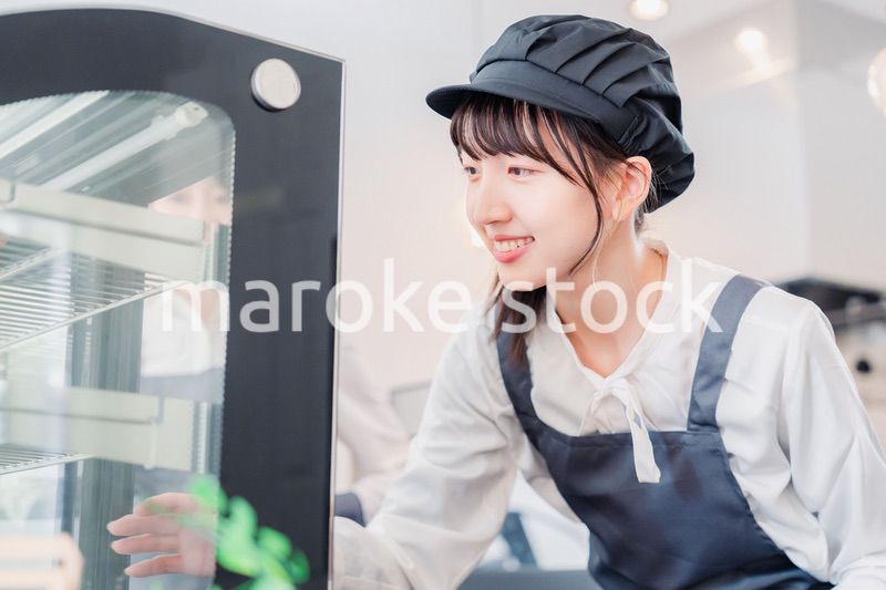 ショーケースに商品を並べる若い店員