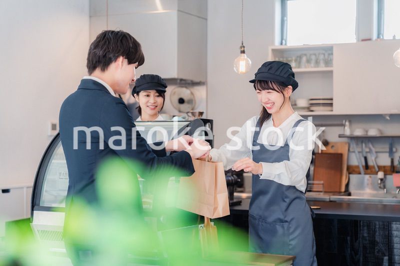 ケーキ屋で楽しく買い物をするビジネスマン