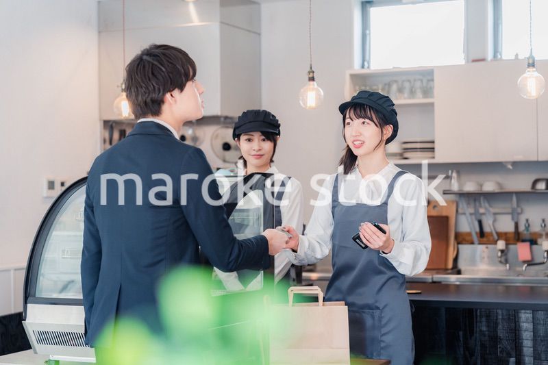 ケーキ屋で楽しく買い物をするビジネスマン