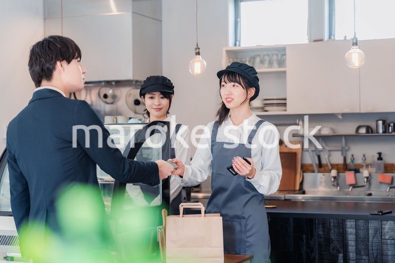 ケーキ屋で楽しく買い物をするビジネスマン