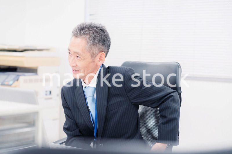 会社で自分の意見を語る管理職の男性