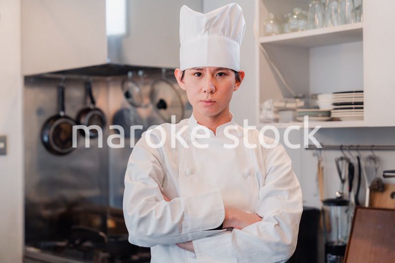 真剣な表情で腕組をする料理人
