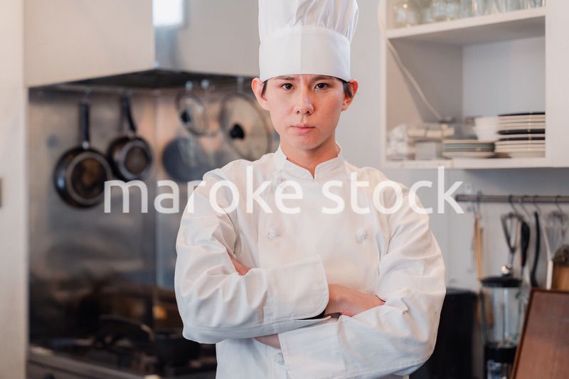 真剣な表情で腕組をする料理人
