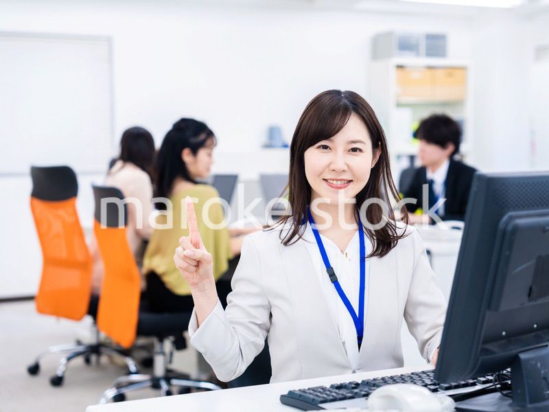 笑顔でポイントを指すビジネスウーマン