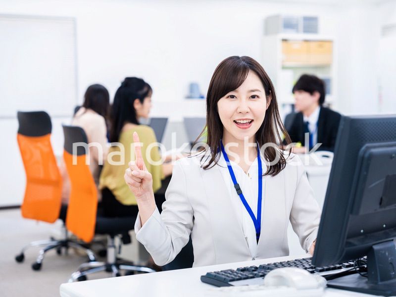 笑顔でポイントを指すビジネスウーマン