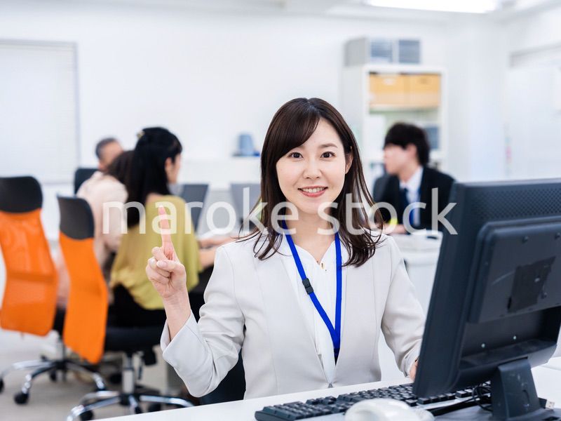 笑顔でポイントを指すビジネスウーマン