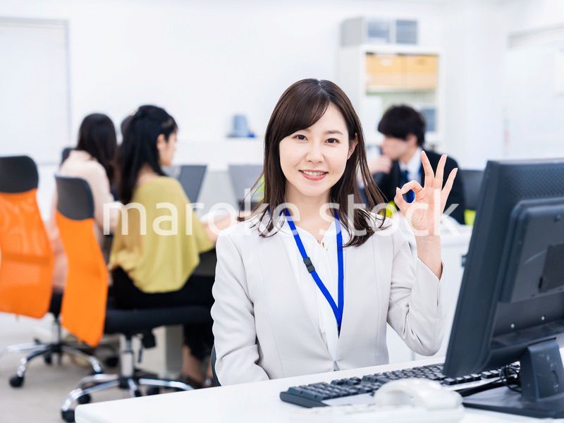 デスクでOKサインをするキャリアウーマン