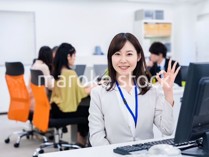 デスクでOKサインをするキャリアウーマン