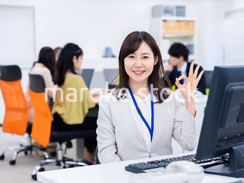 デスクでOKサインをするキャリアウーマン