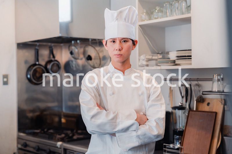 真剣な表情で腕組をする料理人