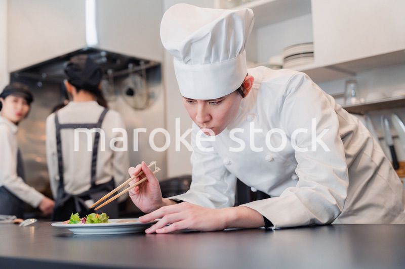 厨房で盛り付けをする男性シェフ